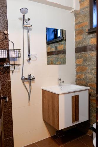 a bathroom with a sink and a shower at Трите къщи in Leshten