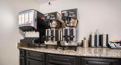 a counter with three coffee machines on it at SureStay Plus Hotel by Best Western Sacramento North in Sacramento
