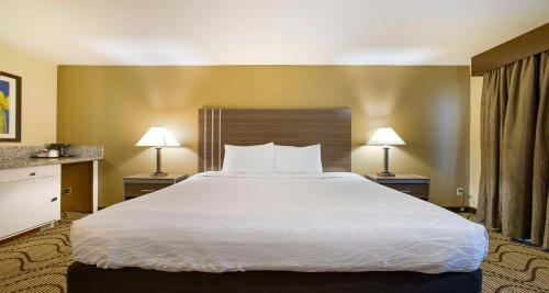 a large bed in a hotel room with two lamps at SureStay Plus Hotel by Best Western Sacramento North in Sacramento