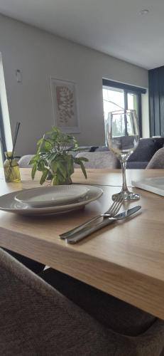 a table with a plate and a wine glass on it at Sleek modern design - 2 bed apartment in Donegal Town in Donegal