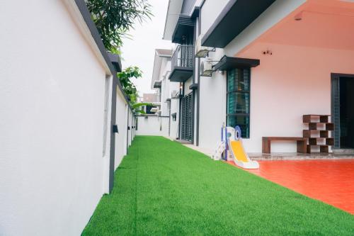an alley with green grass in a building at Rimbayu 4Br-20guest#EventHouse#pooltable in Teluk Panglima Garang