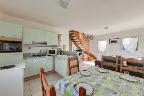 une cuisine et une salle à manger avec une table et des chaises dans l'établissement À 500m de la plage, maison pour 6 avec jardin, à Sarzeau
