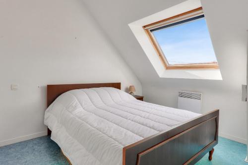une chambre avec un grand lit avec une fenêtre dans l'établissement À 500m de la plage, maison pour 6 avec jardin, à Sarzeau