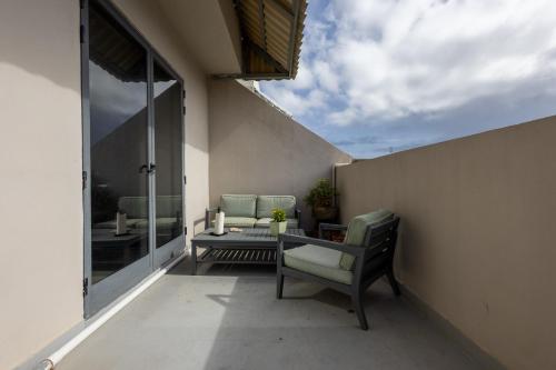 a balcony with a chair and a table on a patio at Penthouse Near Paceville with Private Terrace by QuickTrips in Is-Swieqi