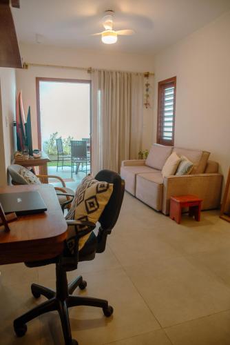 a living room with a couch and a table and a desk at Chalé Compartilhado da Chica - Vila das Andorinhas in Pipa