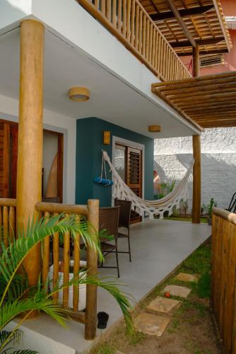 a patio with a hammock on a house at Chalé Compartilhado da Chica - Vila das Andorinhas in Pipa