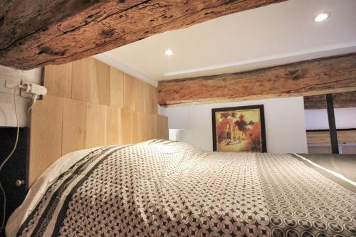 une chambre avec un grand lit avec un plafond en bois dans l'établissement Studio cosy cœur Villeneuve-lez-Avignon, à Villeneuve-lès-Avignon