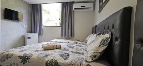 a bedroom with two beds and a large headboard at Hotel Real in Ouro Preto