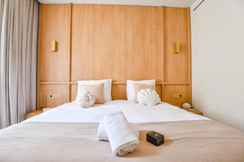 - une chambre avec un grand lit blanc et des murs en bois dans l'établissement L'Adresse 4 - Appart standing - Clim - Vieux-Port, à Marseille