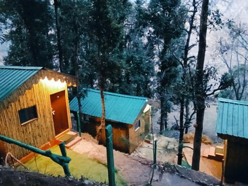 a cabin in the woods with a blue roof at TTN - The Trekker's Nest in Joshīmath