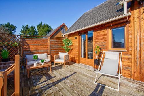 une terrasse avec deux chaises et une table dans l'établissement Chalet cosy - Proche mer, à Cabourg