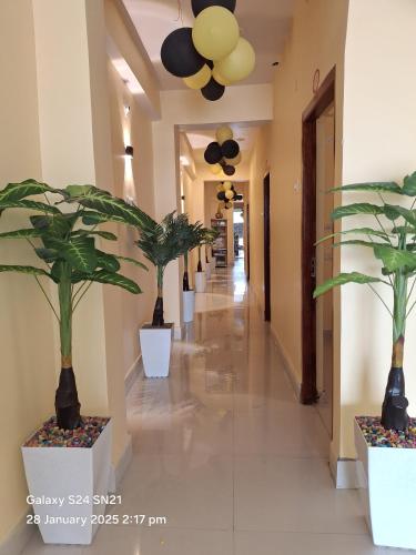 a hallway with potted plants in a building at Hotel Grand Arya in Hilsa