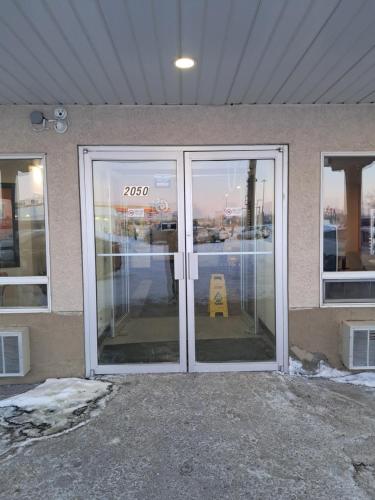 a glass door of a building with a sign on it at Motel 6-Regina, SK in Regina