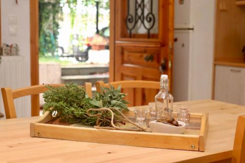 a wooden tray with a bottle and glasses on a table at Tradiotional house in Metamorfosi