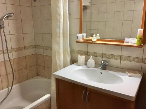 a bathroom with a sink and a shower and a tub at Tradiotional house in Metamorfosi