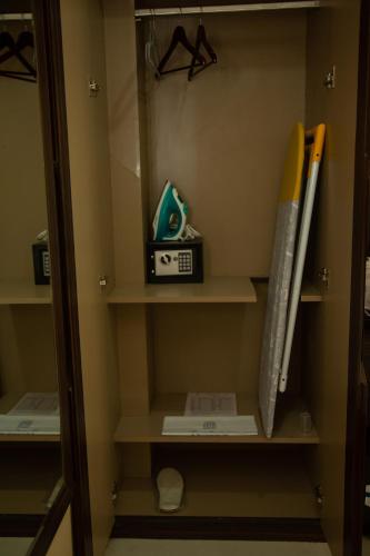 a closet with a shelf with some baseball bats at Park Eastern Hotel in Kolkata
