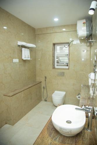 a bathroom with a sink and a toilet at Park Eastern Hotel in Kolkata