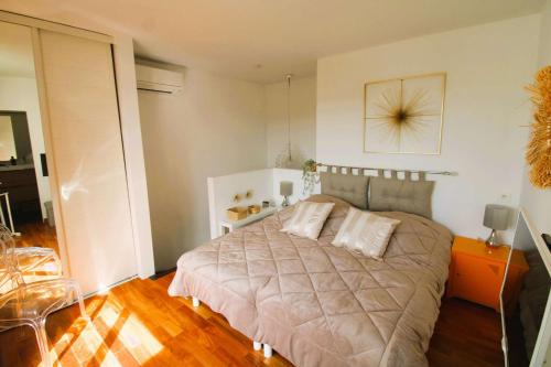 une chambre avec un grand lit avec deux oreillers dessus dans l'établissement MARCOGNEY - Golfe de St-Tropez - Aux Marines de Cogolin - Appartement climatisé vue sur le port, à Cogolin