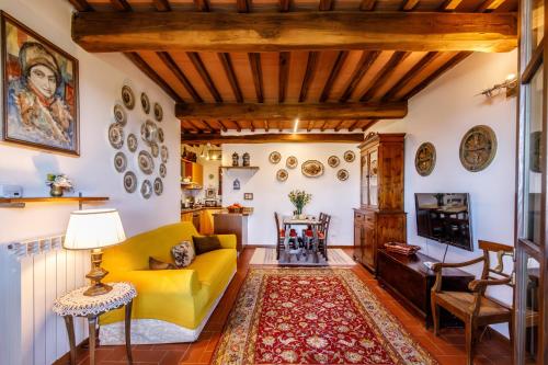 a living room with a yellow couch and a table at Top of hill, with view on Siena, Chianti and Crete in Montaperti