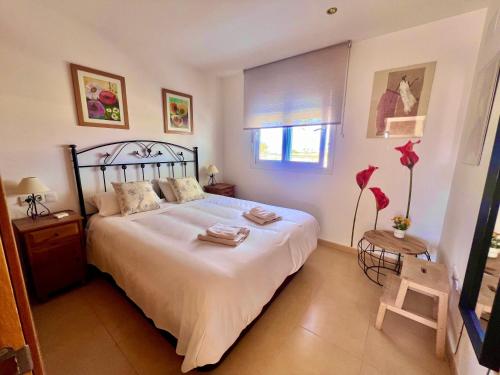 a bedroom with a large white bed and a window at Condado De Alhama, Jardin 10 SV54 in Alhama de Murcia