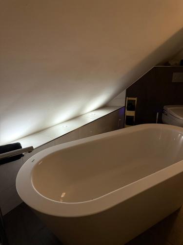 a white bath tub in a bathroom with a toilet at 2 Home in Wettingen