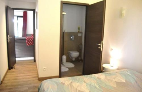 - une chambre avec une porte s'ouvrant sur une salle de bains pourvue de toilettes dans l'établissement Les Bergeries de Petralonga, à Sotta