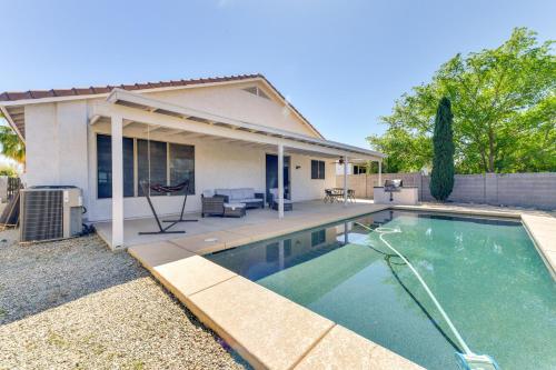 a swimming pool in front of a house at Group Getaway with Pool and Patio in San Tan Valley! in Queen Creek