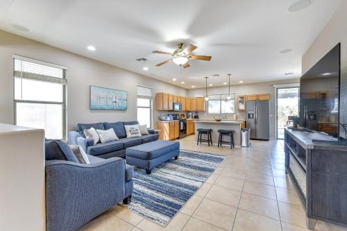 a living room with blue couches and a kitchen at Group Getaway with Pool and Patio in San Tan Valley! in Queen Creek
