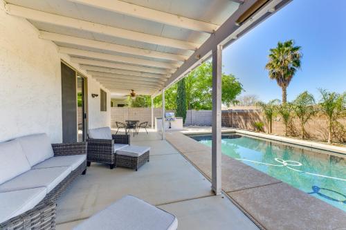an outdoor patio with a couch and a pool at Group Getaway with Pool and Patio in San Tan Valley! in Queen Creek