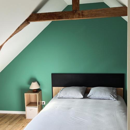 a bedroom with a bed with a blue wall at Maison en centre ville de Langeais in Langeais