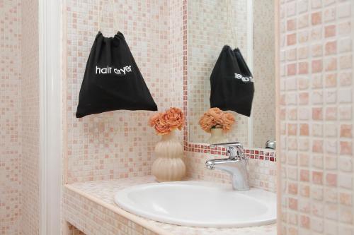 two black bags are hanging on a bathroom mirror at Centro storico - ottimi collegamenti per Roma e APT in Fiumicino