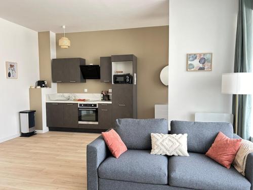 a living room with a couch and a kitchen at Les Remparts, centre-ville d'Hennebont in Hennebont
