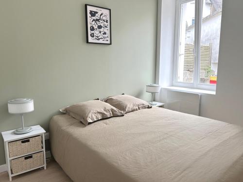 a white bedroom with a bed and a window at Les Remparts, centre-ville d'Hennebont in Hennebont