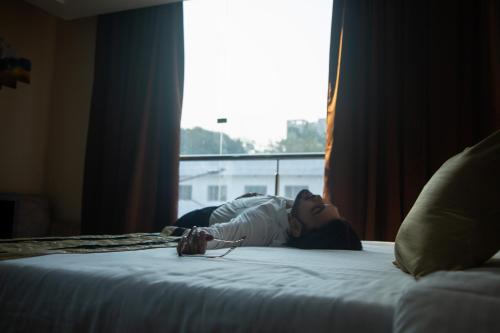 a woman laying on a bed in a hotel room at Park Eastern Hotel in Kolkata