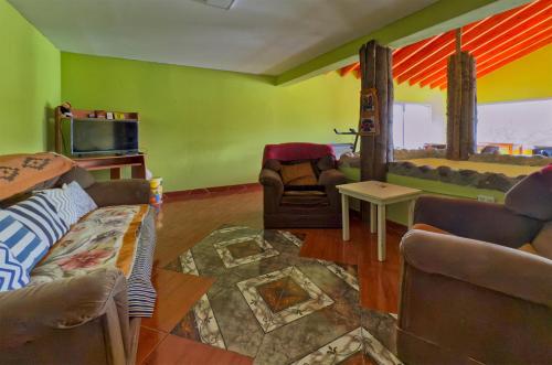 a living room with a couch and a tv at Hostel Familia de Campo in El Chalten