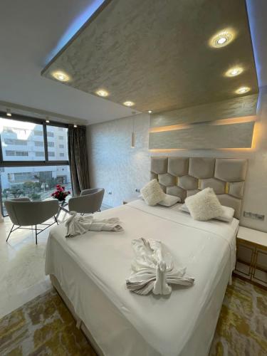 a bedroom with a large white bed with two towels at Appartement al aamira in Tangier