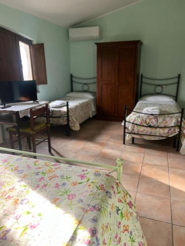 a room with two beds and a table and a desk at Il Vecchio Mulino in Massa Martana