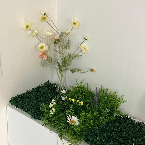 a vase filled with flowers on top of a cabinet at Naroo Stay - DDP and Jong-ro in Seoul