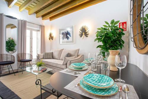 a living room with a table with plates on it at Genteel Home Padre Marchena in Seville