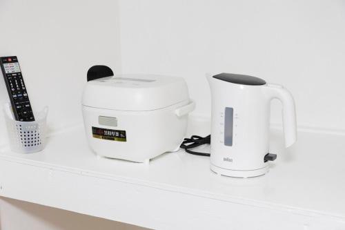 a counter with a coffee maker and a toaster at Forest Guest House Shinjuku city center in Tokyo