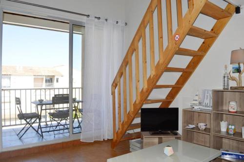 un salon avec un escalier et une télévision dans l'établissement NP170-A259 Appartement 2 pièces mezzanine Narbonne Plage, à Narbonne-Plage
