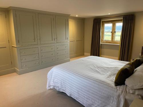 a bedroom with a large white bed and a window at Everdon Hill House - B&B in Great Everdon