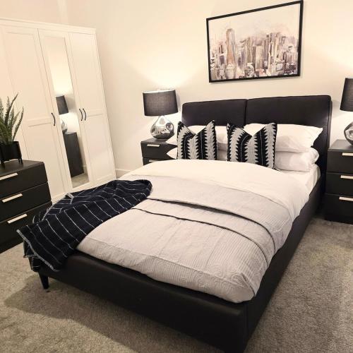 a bedroom with a large bed with black and white pillows at Luxury Flat in Birmingham City West Midlands in Birmingham