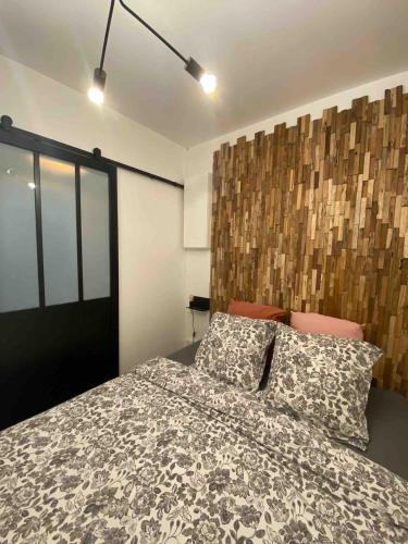 a bedroom with a bed and a wooden headboard at Havre de paix avec jardin et parking à Chantilly in Gouvieux