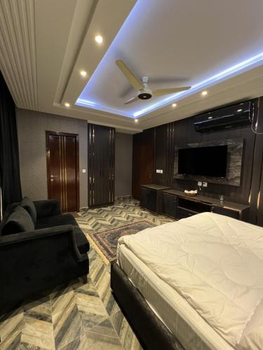 a bedroom with a bed and a flat screen tv at Courteous Hotel in Islamabad