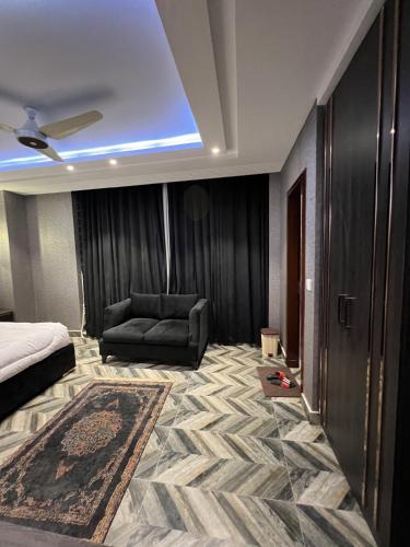 a bedroom with a bed and a couch in a room at Courteous Hotel in Islamabad