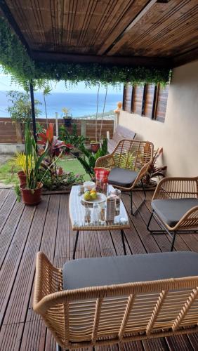 a patio with chairs and a table on a deck at Vacances paisibles - petit déjeuner offert pour la première nuit in Saint-Paul