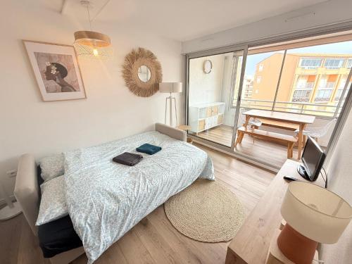 une chambre avec un lit et un balcon dans l'établissement Appart Confort 4-6 Pers Agde,Animaux ok, Plage Richelieu à 150m, Piscine, Parking, Aqualand -, au Cap d'Agde