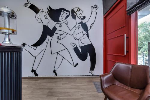 a wall mural of three women dancing in a room at Super Townhouse The AMV Hotel in Gurgaon