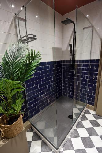 a bathroom with a glass shower with blue tiles at Samuels' a duplex apartment by Spires Accommodation in Lichfield City Centre in Lichfield
